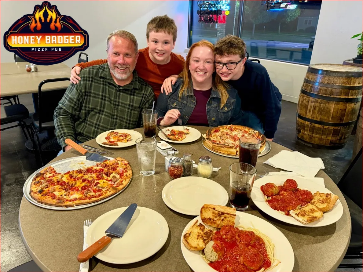A family around a table of pizza and pasta